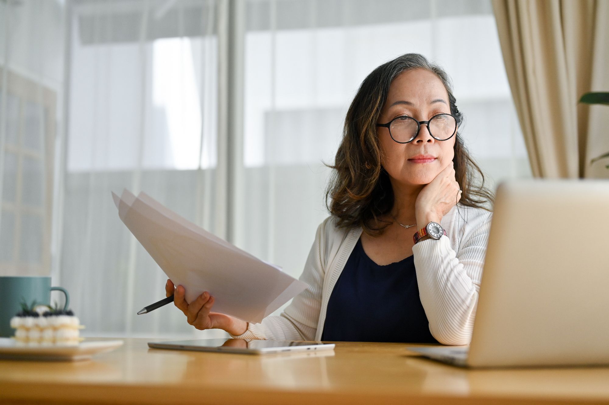Lady looking at a computer holding papers