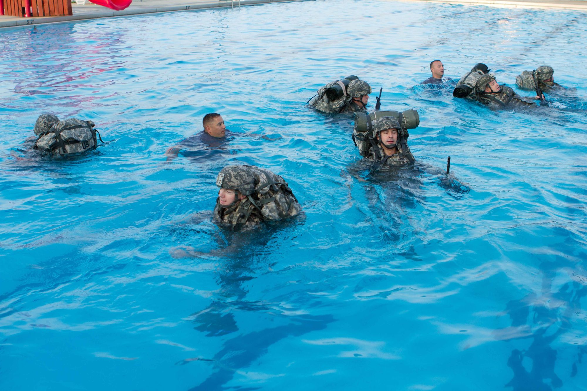 soldiers doing combat survival training inside a pool
